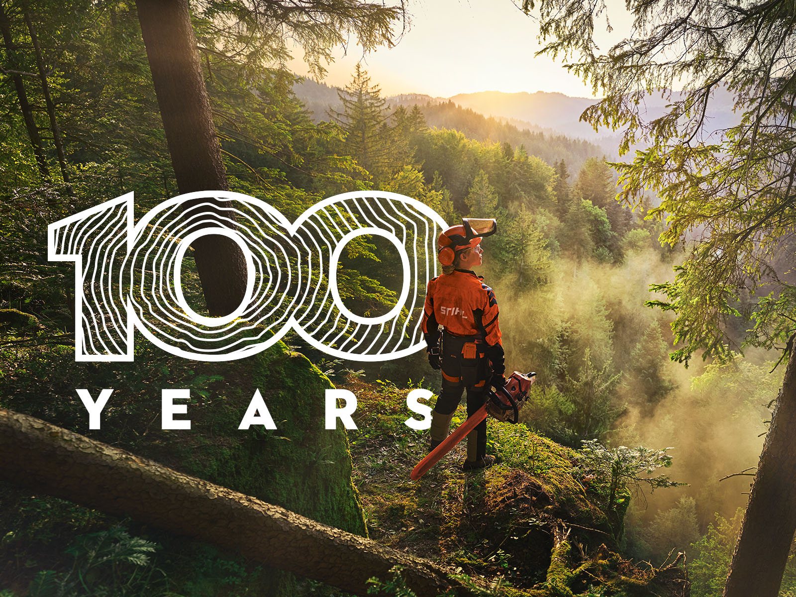 Μία υλοτόμος στο δάσος ατενίζει το και αναγράφεται το λεκτικό 100 χρόνια στα αγγλικά 