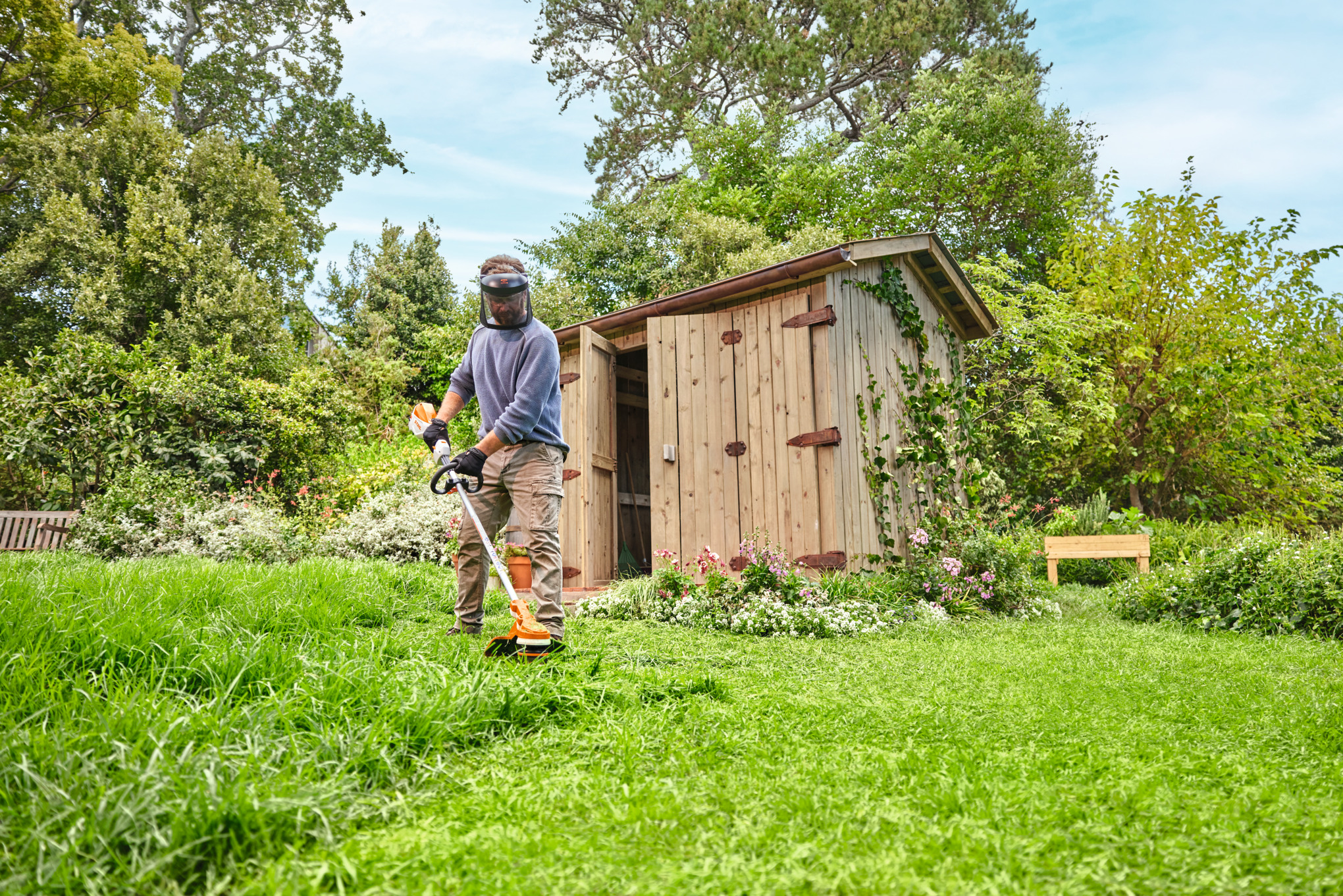  Ένας άνδρας κόβει το γρασίδι με το επαναφορτιζόμενο κοπτικό μηχάνημα STIHL FSA 70 R