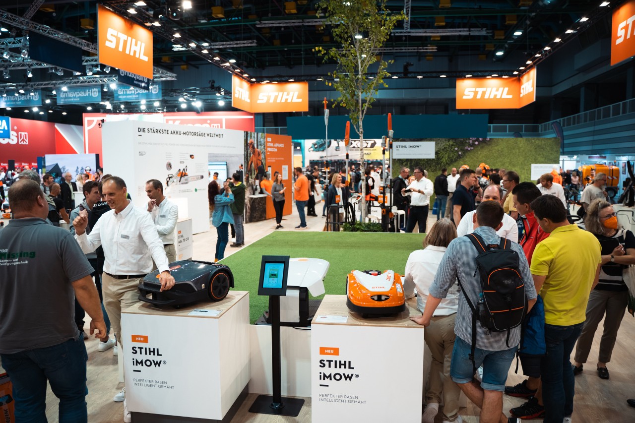 Εκθεσιακό περίπτερο STIHL Indoor με χλοοκοπτικά ρομπότ iMOW® με πλήθος επισκεπτών